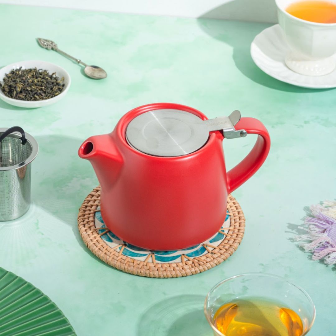 Red teapot in a green background setup