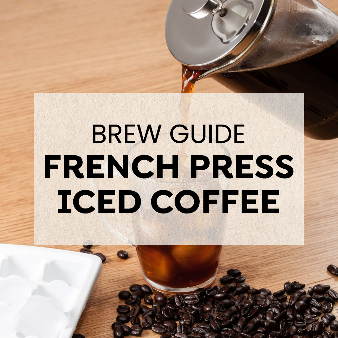 French press pouring coffee over ice in a glass, with coffee beans and an ice tray on a wooden surface, showcasing a refreshing iced coffee brew.