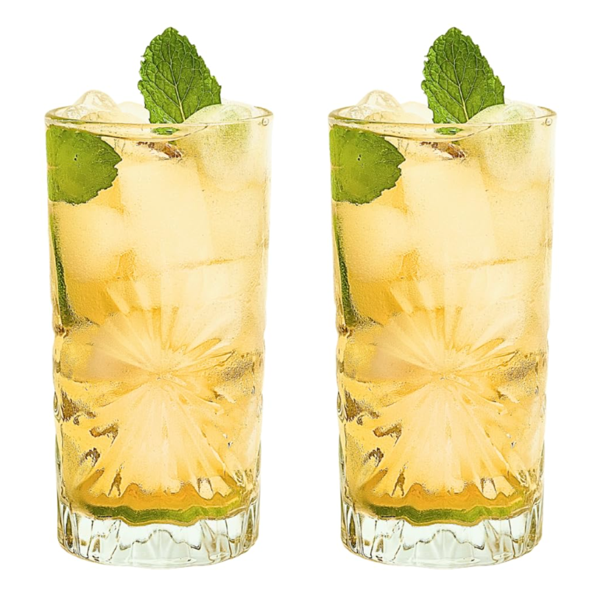 Two tall clear glasses filled with a pale yellow drink, ice cubes, mint leaves, and lime slices, shown side by side on a white background.