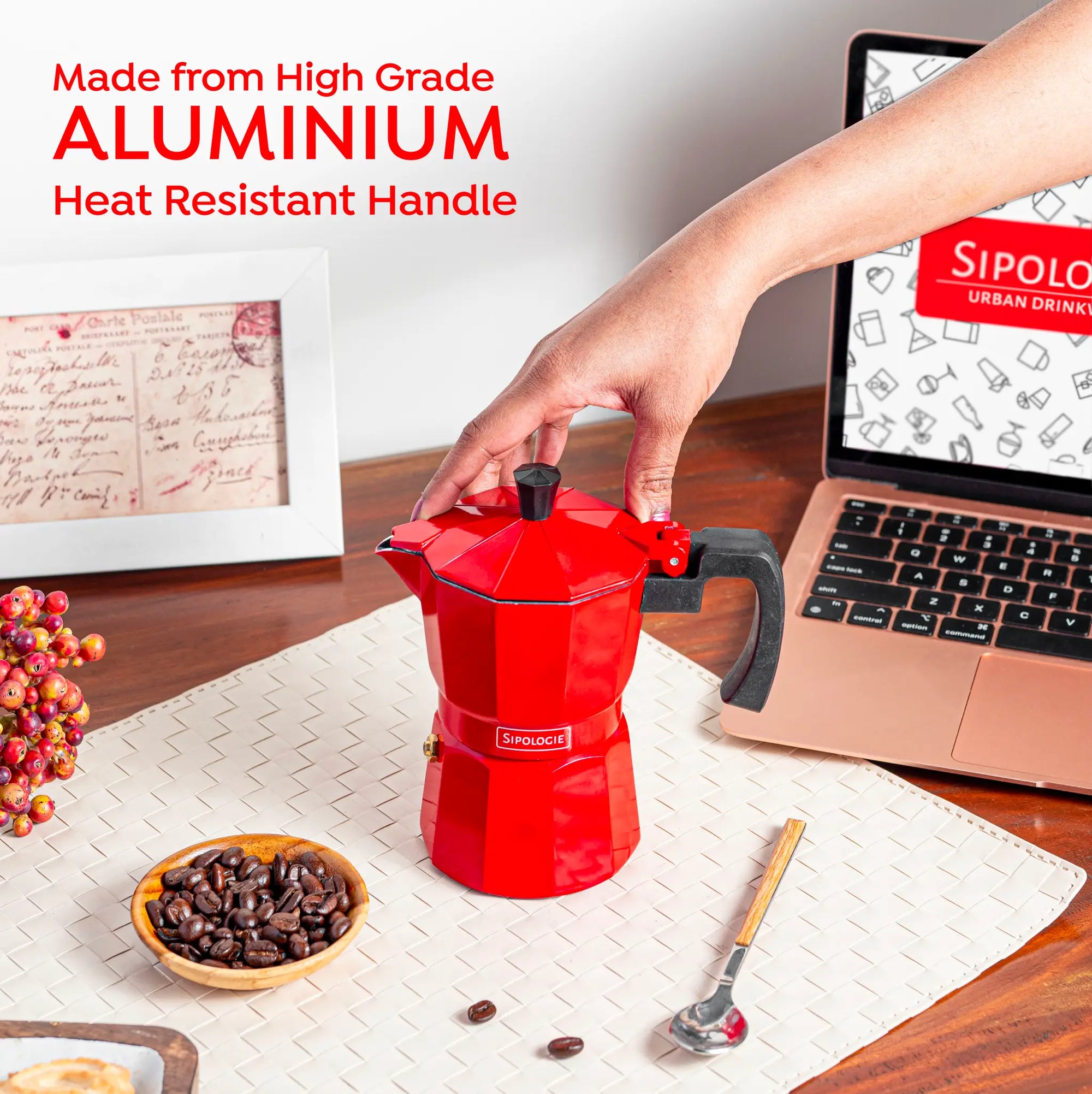 Hand holding the Sipologie red aluminium Moka Pot with heat-resistant handle