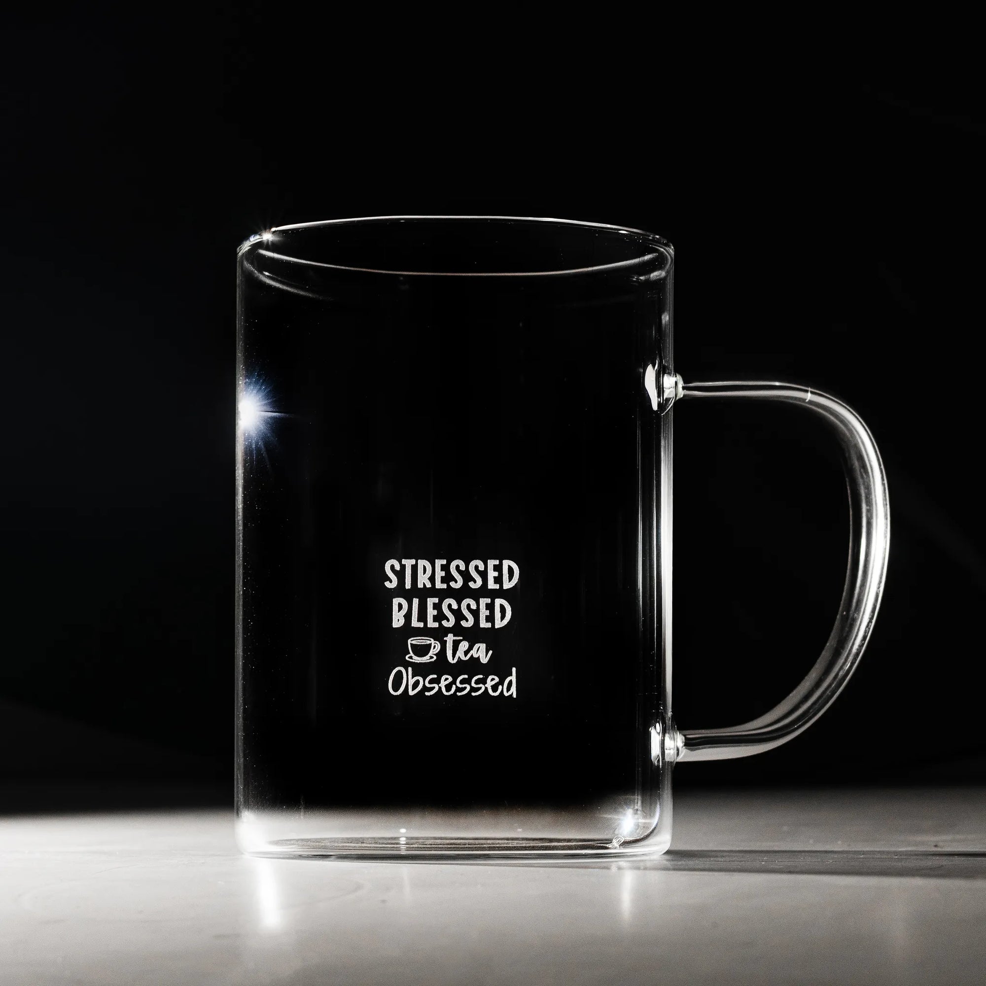 Clear mug with text 'Stressed Blessed Tea Obsessed' on a black background