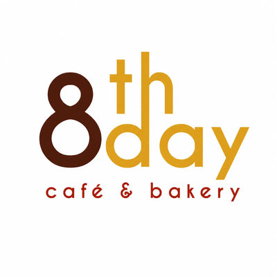 8th Day Cafe & Bakery logo with brown '8', yellow 'th', red 'day', and black 'caçé & bakery' text on a white background.
